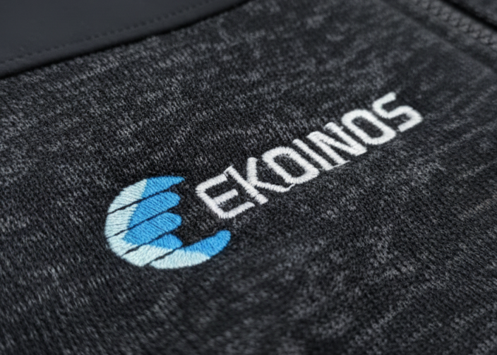 Bordado del logo Ekoinos sobre prenda corporativa NexoWear