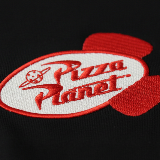Detalle del bordado Pizza Planet de Toy Story en polera - Nexowear.cl