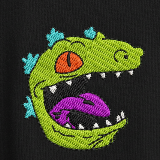 Detalle del bordado de Reptar (Rugrats) en polera - Nexowear.cl